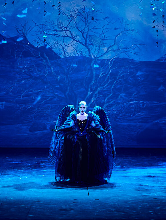 Szene aus "Die Zauberflöte": Sängerin steht mittig auf der Bühne, ein Sänger kniet links neben ihr